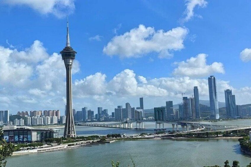 A cityscape with a prominent tower, a river, and a bridge. 1