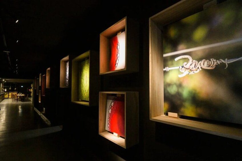 A dimly lit gallery with framed artworks on display. 3