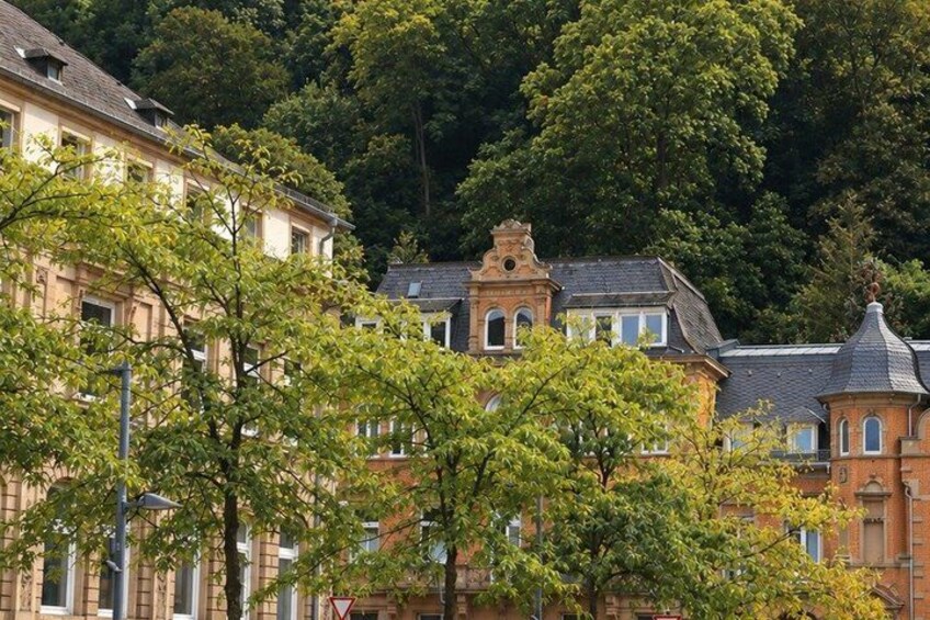 A historic building with a turret, surrounded by lush green trees. 2