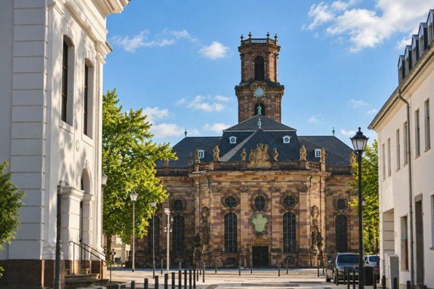 A historic building with a clock tower, arched windows, and a statue on the roof. 3