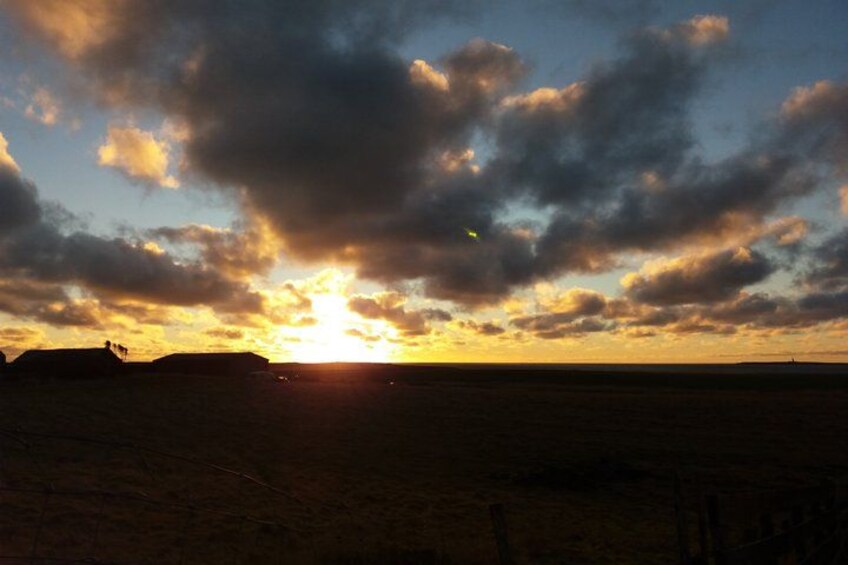 A sunset over a flat landscape with clouds. 3