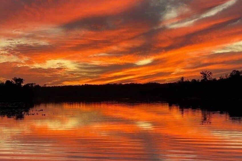 A sunset over a body of water with a reflection of the sky. 5