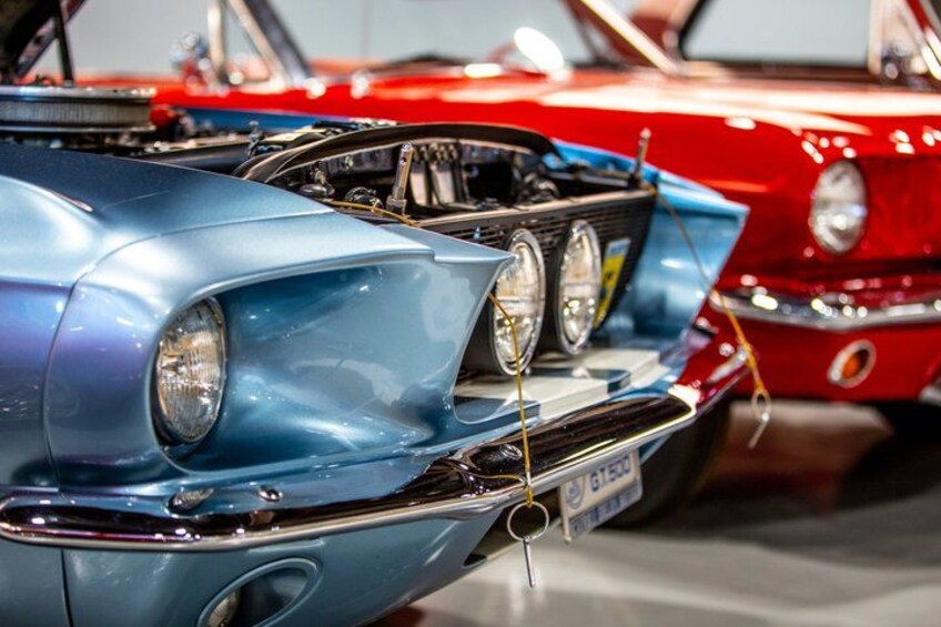 A vintage car with a visible license plate, chrome details, and a hood ornament. 5