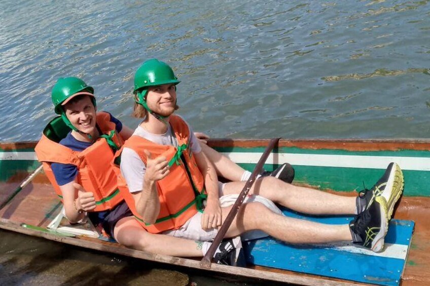 Two people in a boat wearing life jackets and helmets. 3
