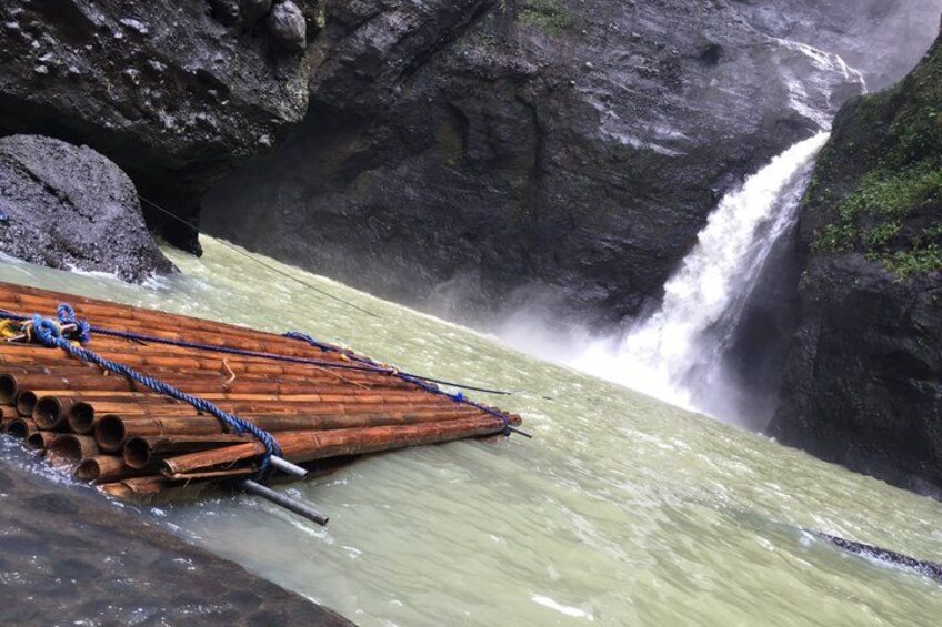 A river with a wooden raft and a waterfall. 1