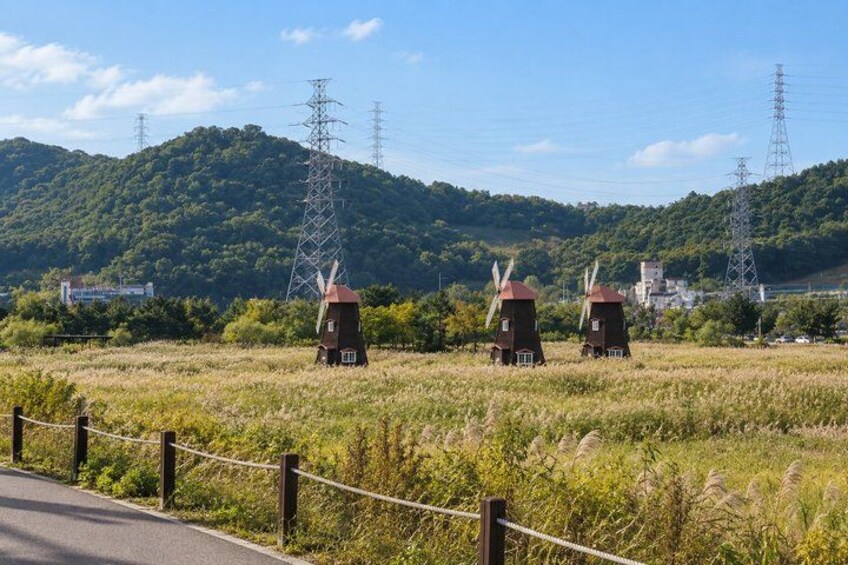 Windmills, a road, and a hilly landscape with power lines. 5