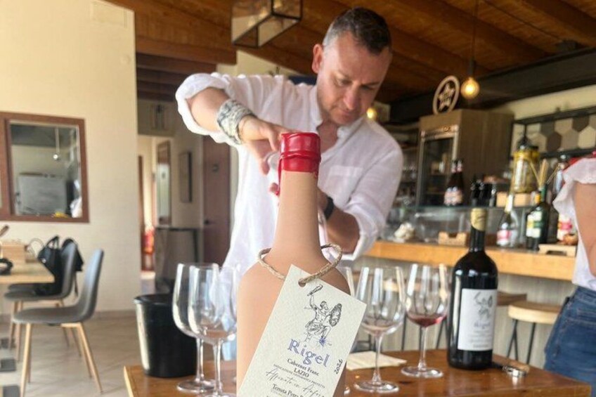 A person pouring wine from a bottle into a glass. 2