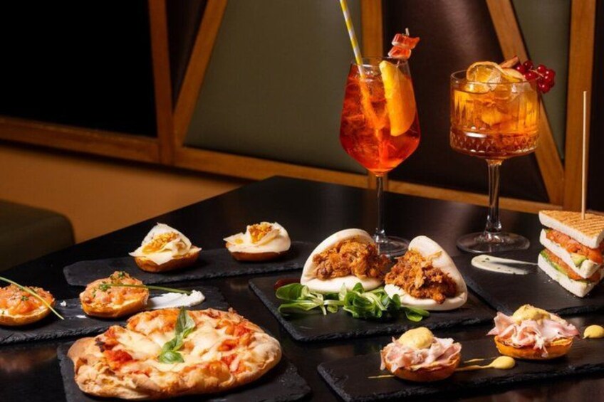 A variety of food items on a table, including pizzas, sandwiches, and appetizers. 4