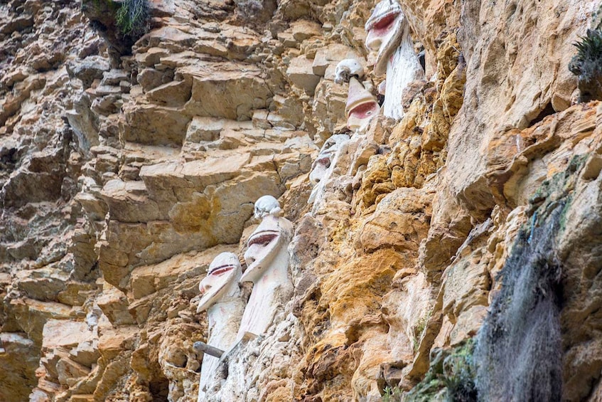 A rocky cliff with ancient stone statues. 3