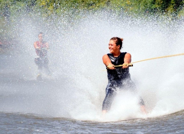 A person water skiing with a wakeboard, being pulled by a boat. 1
