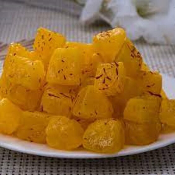 A plate of yellow, cubed fruit, possibly mangoes, with a textured surface. 2
