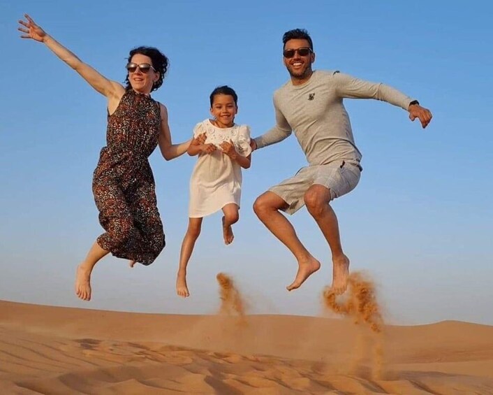 Una familia saltando en el aire con un paisaje desértico al fondo. 4