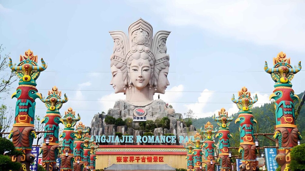 Une grande statue à plusieurs têtes, entourée de totems colorés. 5