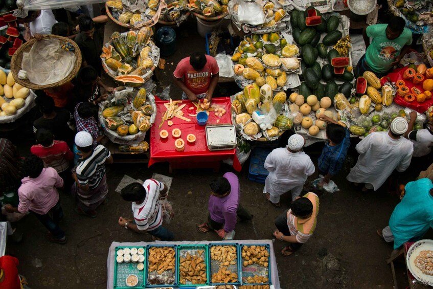 A bustling market with vendors selling fruits, vegetables, and snacks. 2