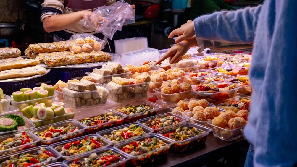 A variety of food items displayed in containers, including pastries and salads. 4