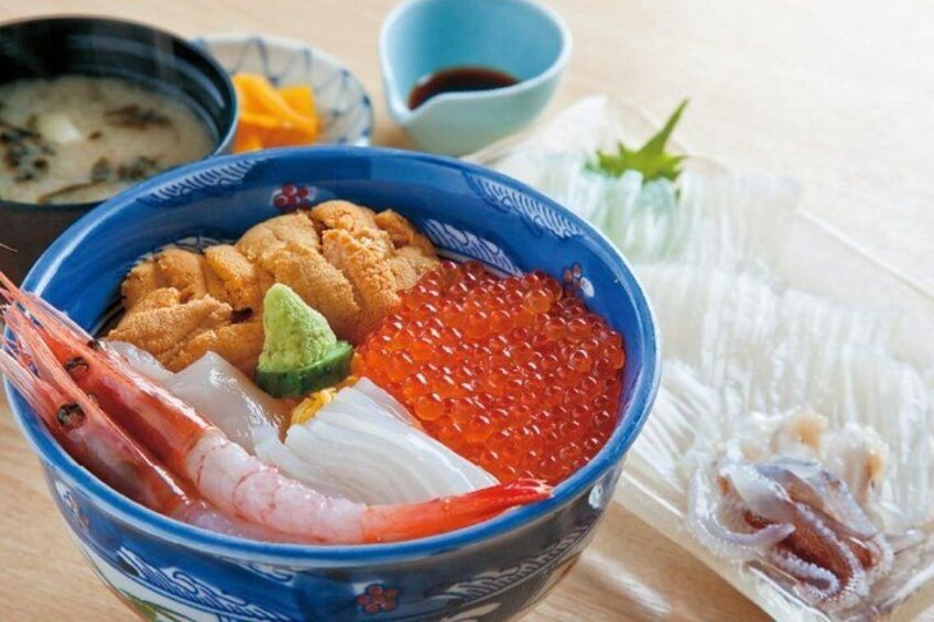 A bowl of sashimi with shrimp, fish roe, and avocado. 3
