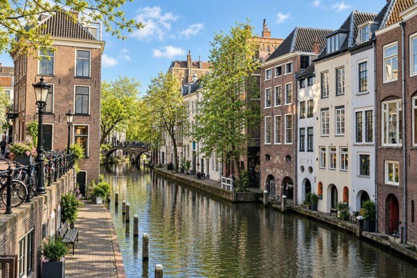 A canal lined with historic buildings, a bridge, and a bicycle. 4