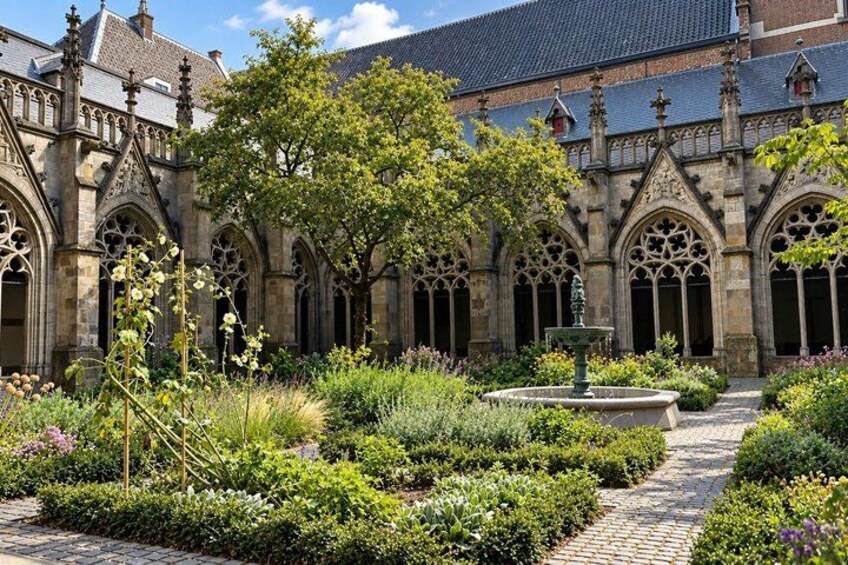 A courtyard with a fountain, surrounded by lush greenery and historic stone architecture. 3