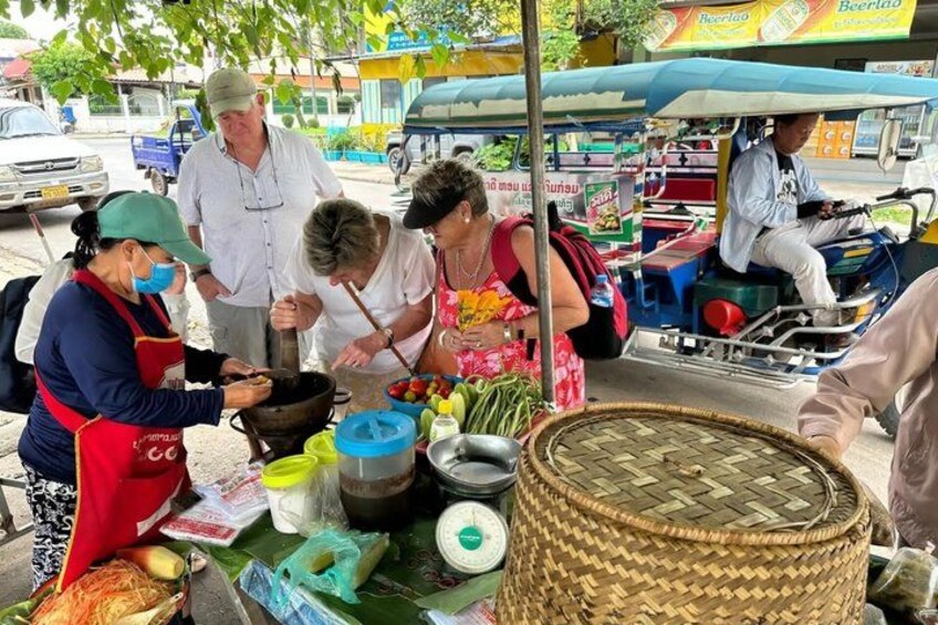 A street food vendor preparing food at a stall with a woven basket and cooking utensils. 1