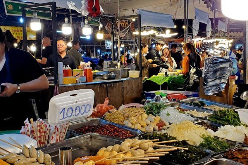 A bustling market with various food stalls, including seafood and fresh produce. 2