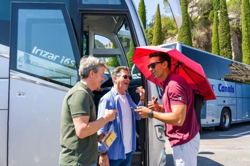 Three people interacting near a bus with 'Canals' written on it. 3