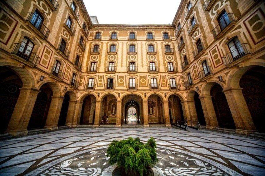 A courtyard with a central fountain, surrounded by classical architecture with arched doorways and detailed stonework. 2