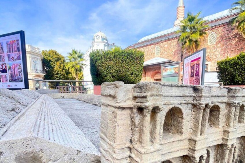 Ancient ruins with stone arches, a mosque with a dome, and a clear blue sky. 3