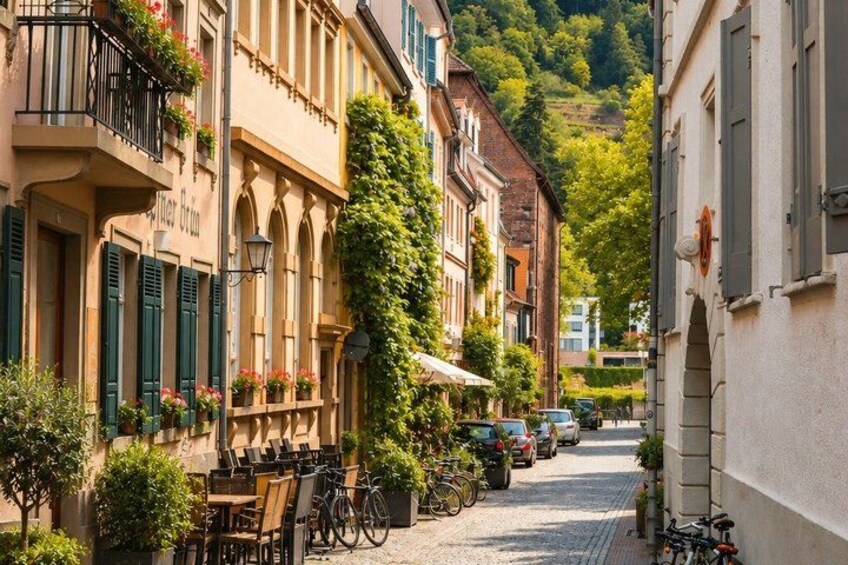 A narrow cobblestone street lined with historic buildings, bicycles, and outdoor seating. 4