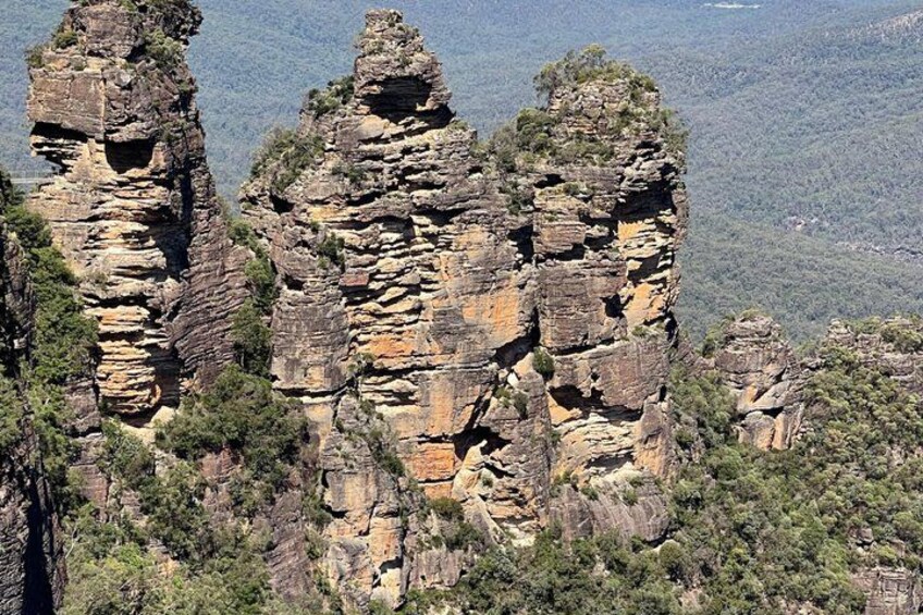 A rugged cliff formation with layered rock structures and sparse vegetation. 3