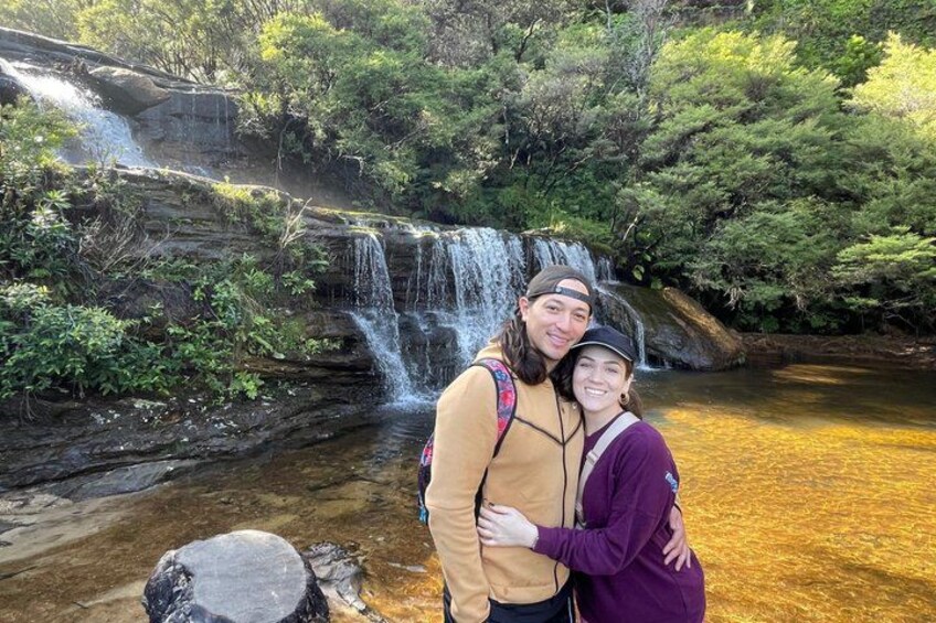 A waterfall, a person in a yellow jacket, and a person in a purple jacket. 5
