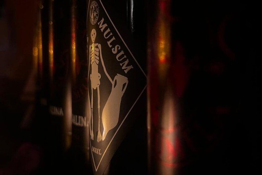 A bottle with a label that includes the text 'MULSUM' and a graphic of a skeleton. 4