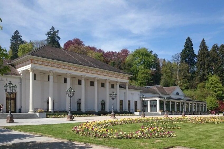 A classical building with columns, surrounded by a well-maintained garden with various flowers. 5