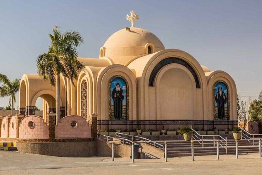 A beige church with arched windows and a dome, surrounded by palm trees and a staircase leading to the entrance. 3