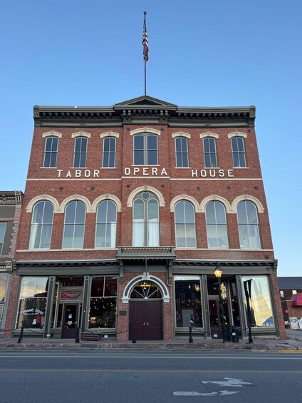 A brick building with arched windows and a sign that reads 'Labor Opera House.' 1