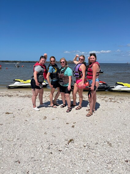 A group of people on a beach with watercraft in the background. 3