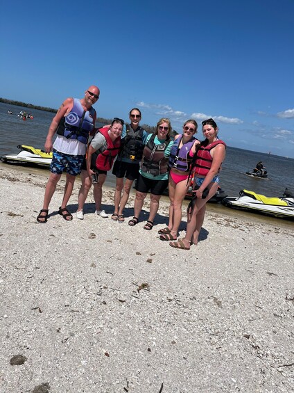 A group of people on a beach with watercraft in the background. 2