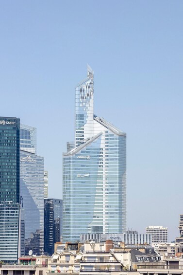 Un gratte-ciel moderne au design original, entouré d’autres immeubles de grande hauteur dans un environnement urbain. 2