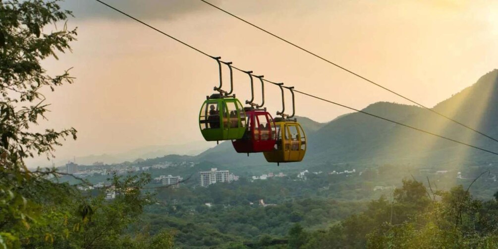 A cable car system with multiple cabins suspended by cables against a backdrop of mountains and a cityscape. 5