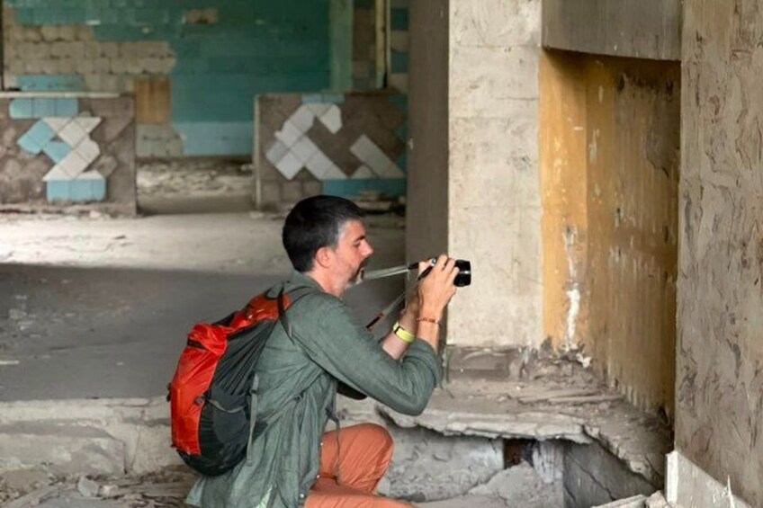 A person crouching and taking a photo with a camera. 2