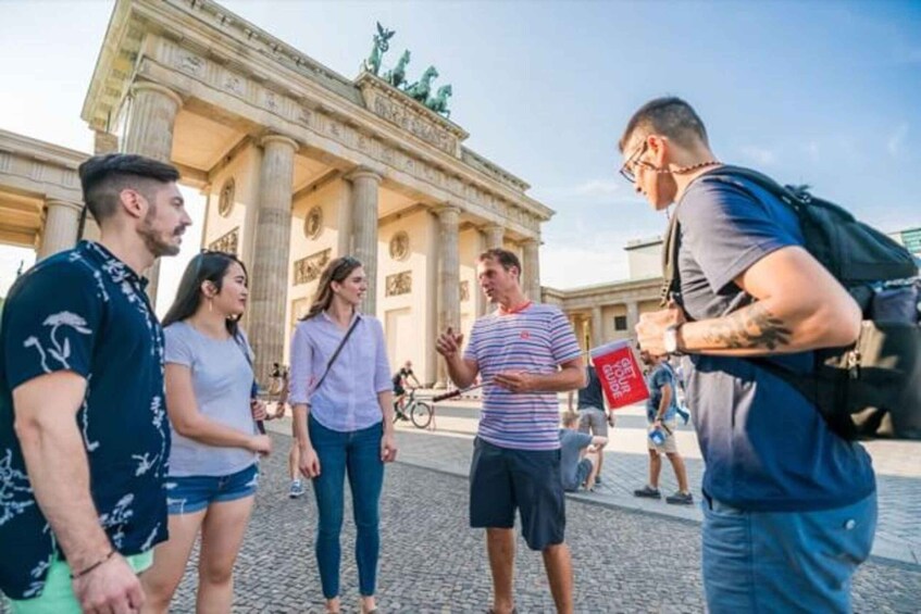 A group of people standing in front of a large classical building with columns and statues. 3