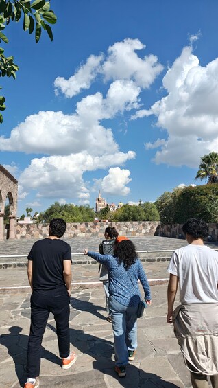 A group of people walking on stone steps towards a historic building with a spire. 4