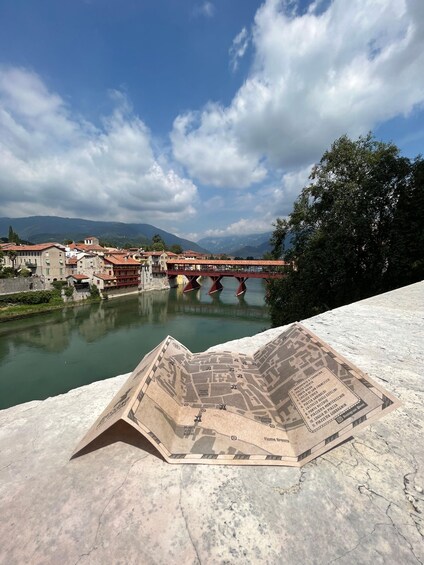 A river with a bridge, buildings, and a map on a stone surface. 5