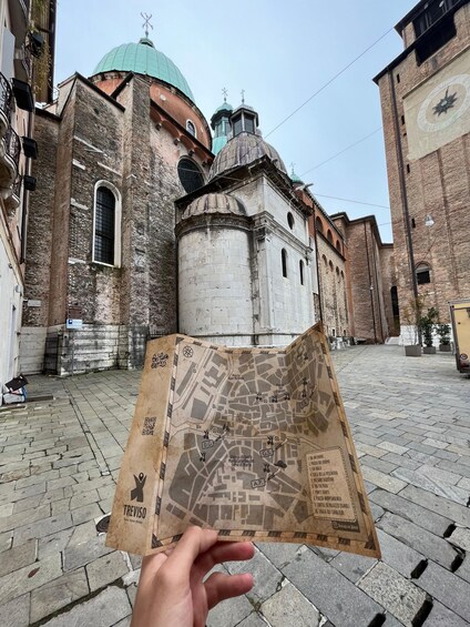 A hand holding a map with a historic building in the background. 2