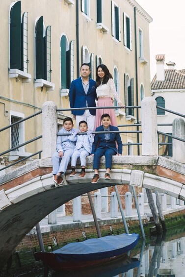 A family on a bridge with a canal and buildings in the background. 4