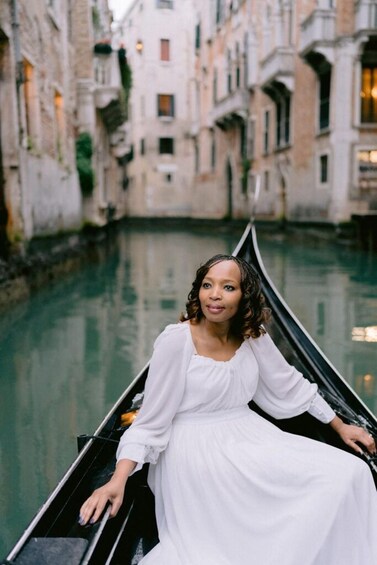 A gondola on a canal with buildings in the background. 1