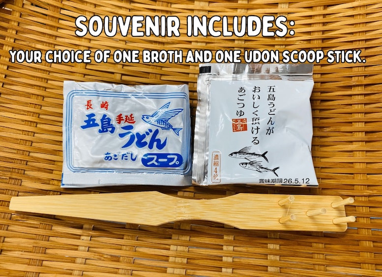 Two packets of Japanese fish food and a wooden scoop stick on a woven mat. 5