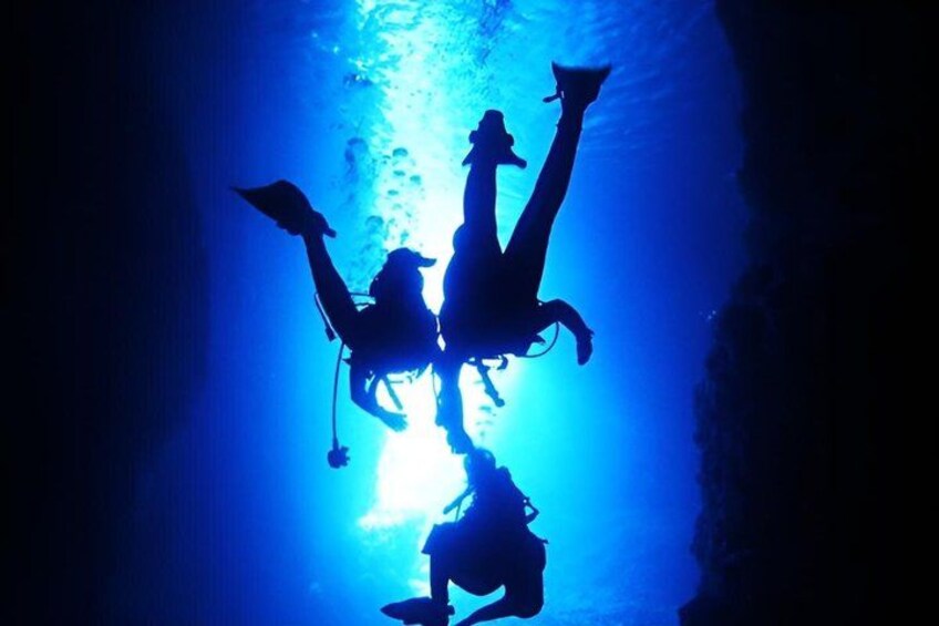 Two divers in a blue-lit underwater environment. 5