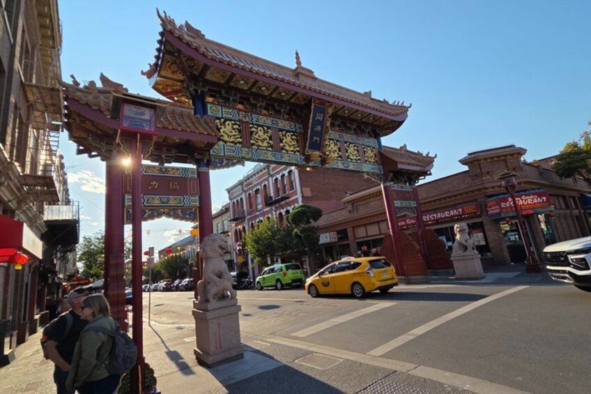 A traditional Chinese gate, a statue, and a restaurant. 3