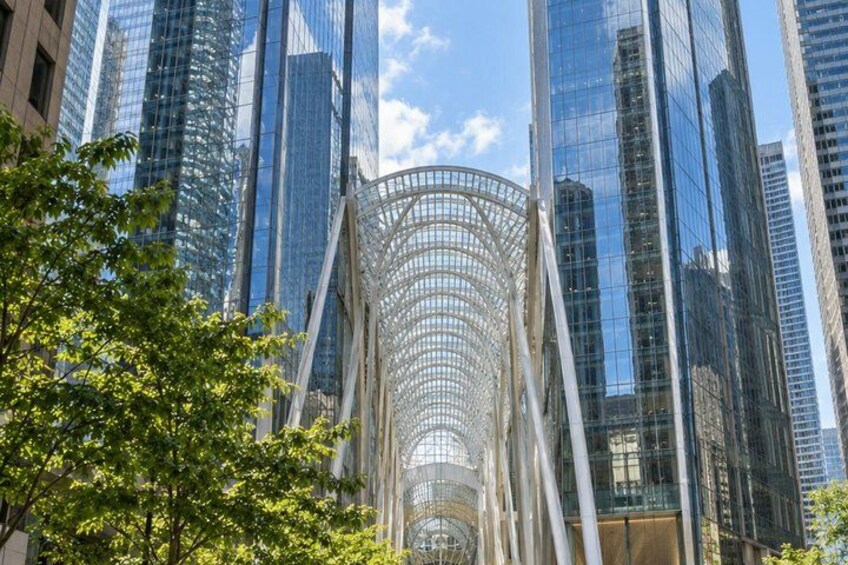 A modern glass building with a unique curved glass facade, surrounded by other high-rise buildings. 4