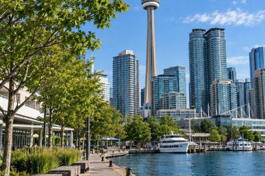 A waterfront cityscape with modern buildings, a prominent tower, and a cruise ship docked near the water. 2
